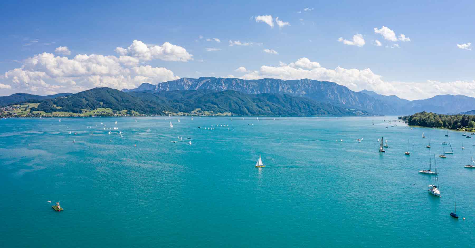 Der Badestrand mit Badekabinen im Häuplhof direkt am Attersee